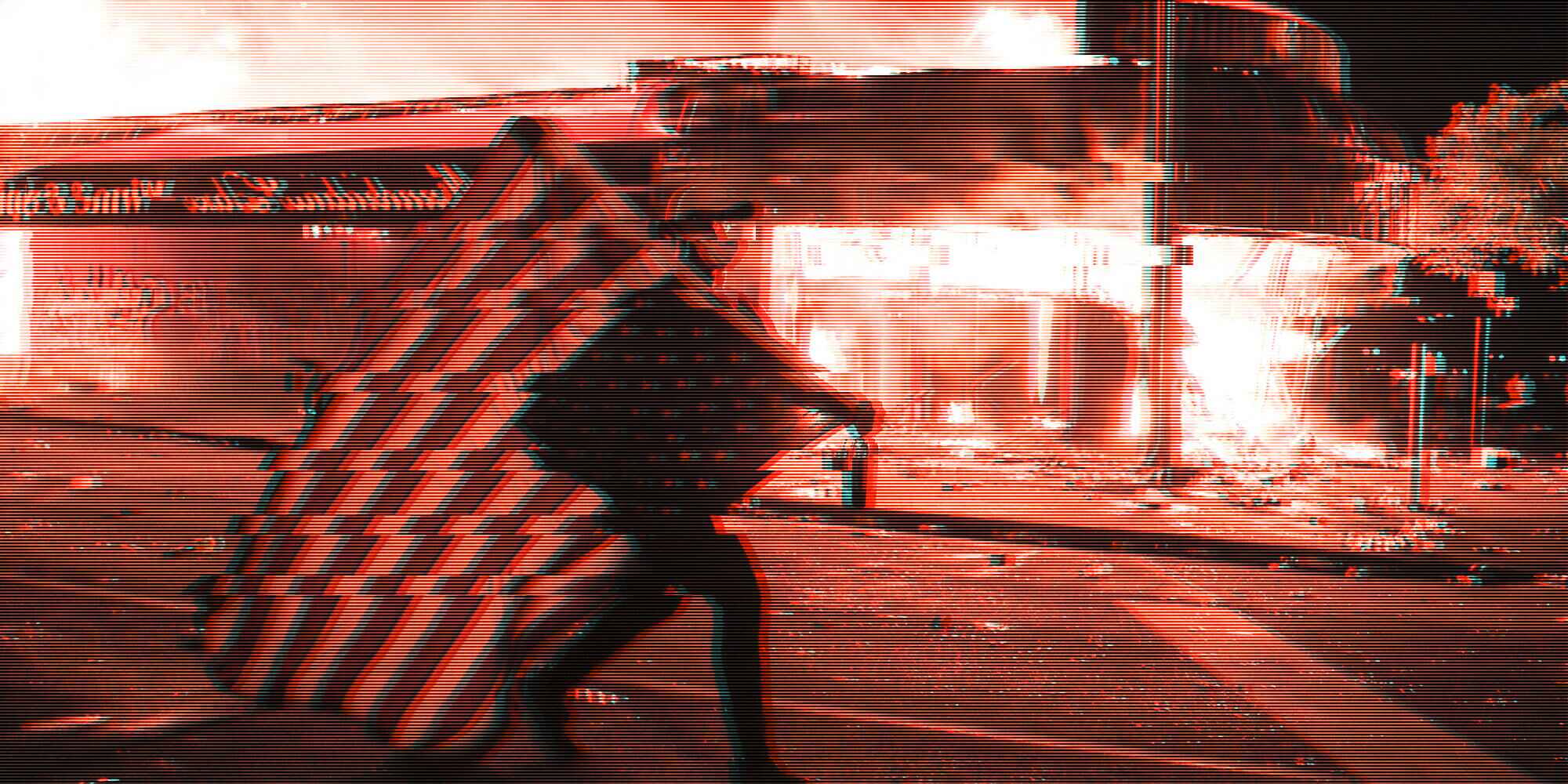 A person is carrying an American flag next to a burning building during a riot