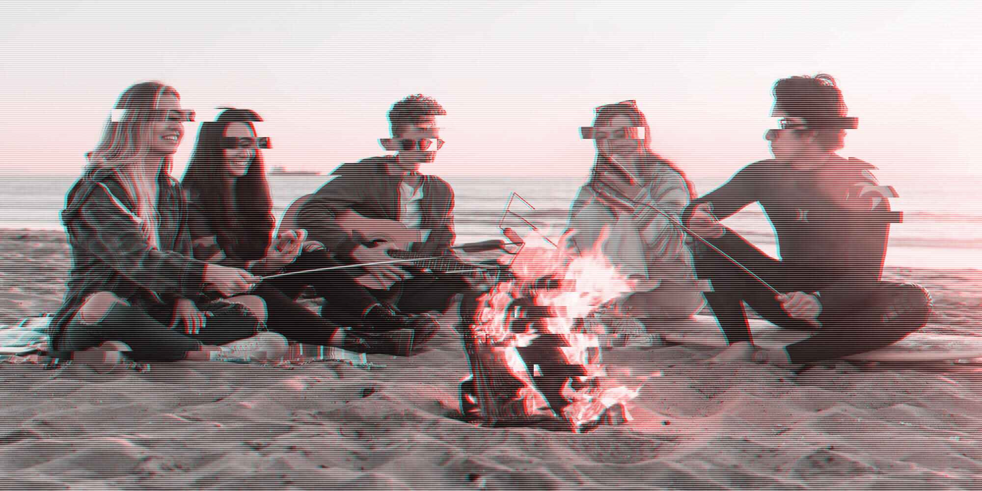 Young people enjoying campfire on the beach