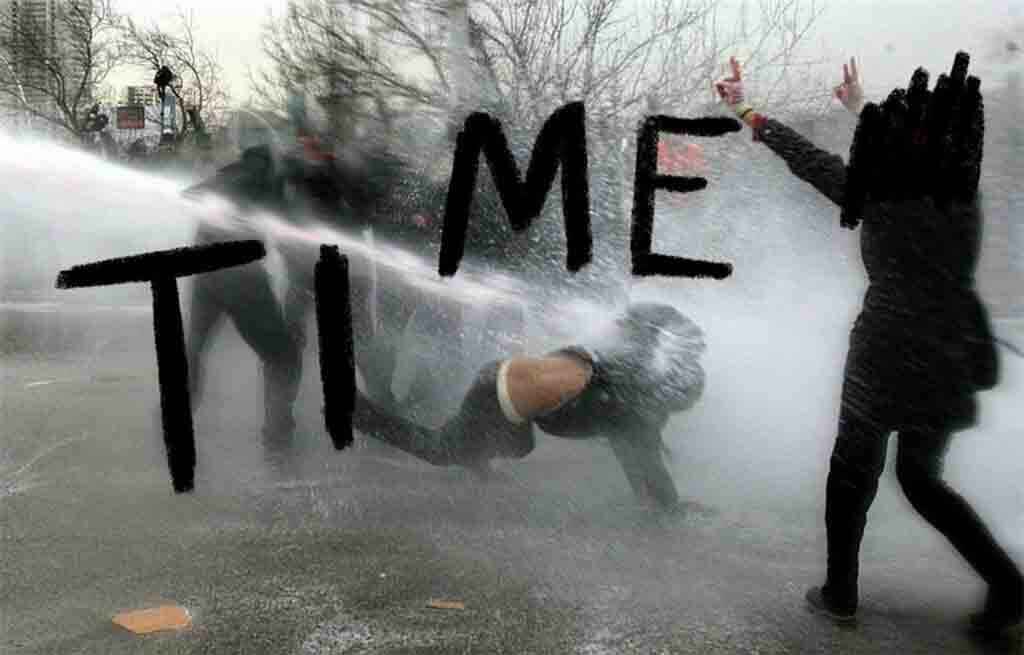 protesters being knocked down by a water cannon